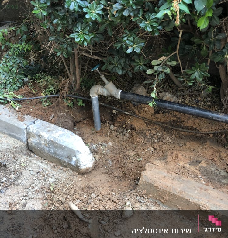 צינור מים שחור עם ברז בגינה